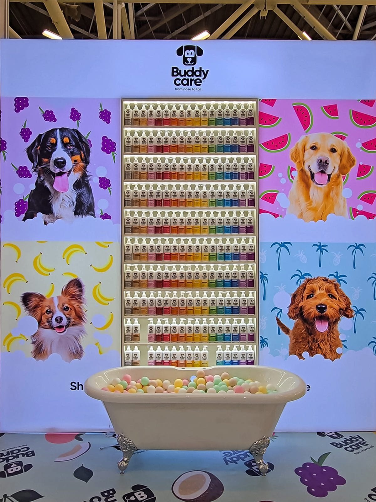 Recessed shelving integrated into a modular exhibition stand wall, displaying colourful product bottles illuminated with LED lighting at a trade show.